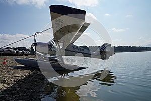 Side view on floatplane or seaplane with two slender floats mounted under the fuselage to provide buoyancy on the lake
