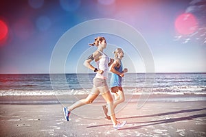 Side view of friends jogging at beach