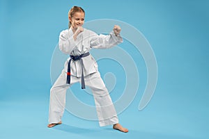 Side view of girl doing martial arts on isolated background