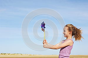 Side View Of Girl With Pinwheel On Beach