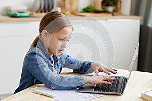 Side View at Girl Using Laptop for Studying at Home