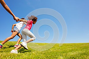 Side view of girls run on the grass park field