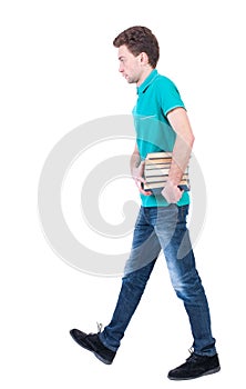 Side view going man carries a stack of books.