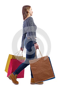 Side view of going woman with shopping bags