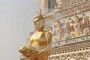 Side view of golden buddha statue with stupa and sky as background. Wat Arun temple in Bangkok, Thailand