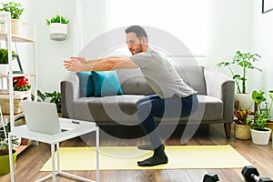 Side view of a good-looking man exercising at home