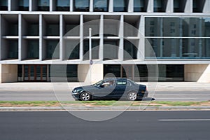 Side view of a green executive and luxury Jaguar S-Type driving in the city