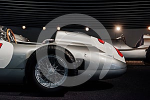 Side view of grey retro sport coupe cabriolet with wooden steering wheel, close up shot of spoke alloy discs and vintage