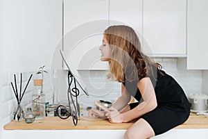 Side view of a grinning little girl looking in the mirror at her missing teeth