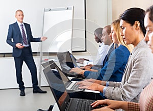 Side view of a group of businessmen undergoing training under the guidance of teacher