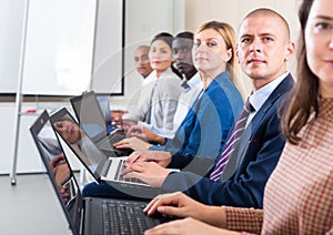 Side view of a group of businessmen undergoing training under the guidance of teacher