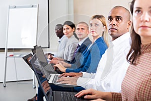 Side view of a group of businessmen undergoing training under the guidance of teacher