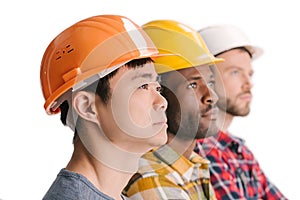 side view of group of multiethnic thoughtful construction workers