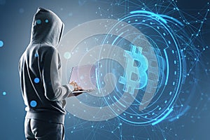Side view of hacker holding laptop with creative round money sign on blurry blue polygonal background. Crypto, hacking, online