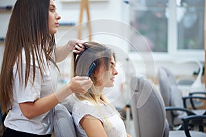 Side view of hairdresser doing bouffant to customer in beauty salon