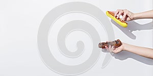 Side view of hands with traditional french eclairs over white background with copy space.