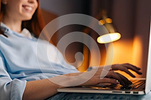 Side view hands of young business woman working typing on keyboard laptop computer, close-up.