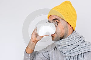 Side view of handsome male having sore throat influenza. Portrait of sick man have grippe and drinking cup of tea, wearing glasses photo