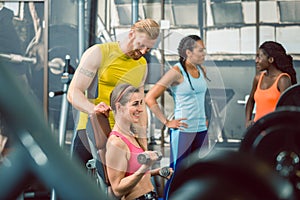 Side view of a handsome personal trainer guiding his client