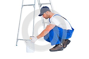 Side view of handyman with paint can on white background