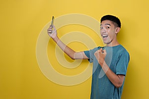 Side view of happy asian man using smartphone