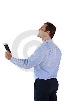 Side view of happy businessman holding tablet computer