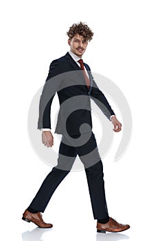 Side view of happy businessman smiling while walking