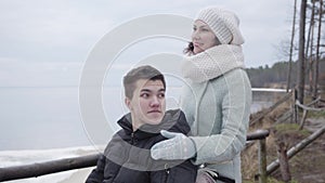 Side view of happy Caucasian disabled boy and adult woman enjoying autumn day outdoors. Son and mother looking at each