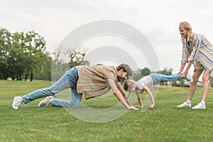 side view of happy family having fun on green grass