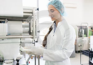 Happy employee wearing lab coat while handling sterile wipes photo