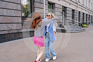 Side view of happy sisters couple having long-awaited meeting after separation. Two cheerful women friends embrace