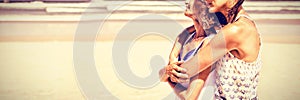 Side view of happy woman embracing her mother at beach