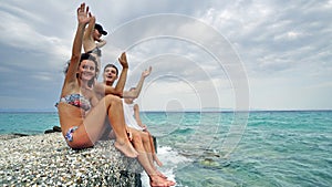 Young teens having party singing and clapping hands smiling on pier