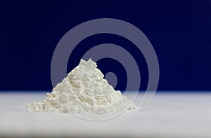 Side view of heap of white modified starch isolated on blue and gray background