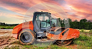 Side View: Heavy construction vehicle of a Single Drum or three wheeled roller for compacting soil.