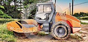 Side View: Heavy construction vehicle of a Single Drum or three wheeled roller for compacting soil.