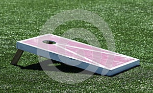 Side view of homemade cornhole game on turf field