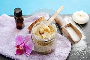 Side view of homemade sugar scrub in glass jar with ingredients for decoration.