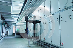 Side view of the huge gray industrial air handling unit in the ventilation plant room