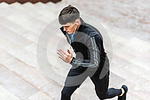 Side view image of young athelte man running in the morning on the fog lake background. Muscular male exercising in the park and photo