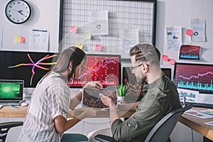 Side view of information security analysts using charts while testing security