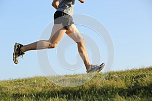 Side view of a jogger legs running on the grass