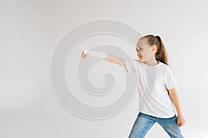 Side view of joyful sweet little girl with broken hand wrapped in white plaster bandage playing gesturing with injured