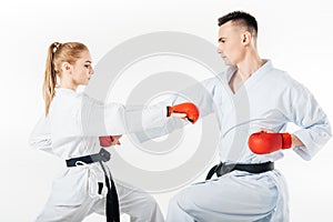 side view of karate fighters training in kimono and red gloves