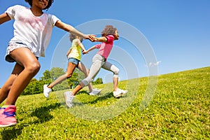 Side view of kids running on the grass park field