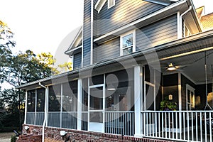 Side view of a large two story blue gray house with wood and vinyl siding