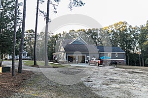 Side view of a large two story blue gray house with wood and vinyl siding