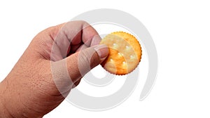 Male hand holding round cracker cookie isolated on white background