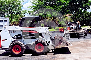 Side view of loader & rear view of flatbed trailer