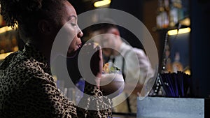 Side view of lonely pretty woman drinking at bar